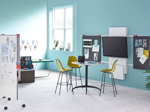 An office setup with stool seating, a ping pong table, and various media. An office setup with stool seating, a ping pong table, and various media.