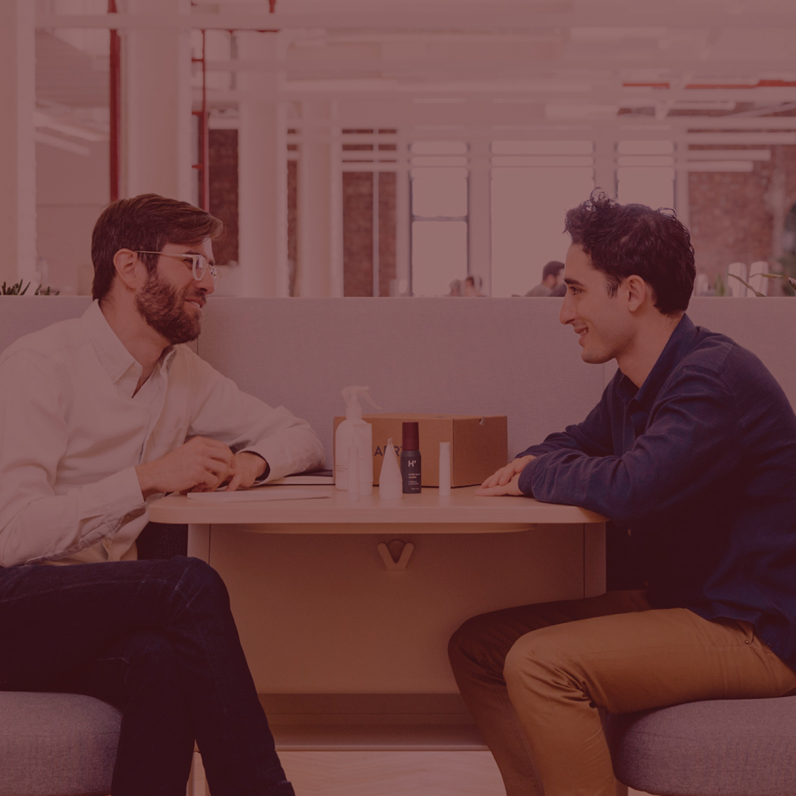 A pair of coworkers are having an impromptu meeting near the main work area. Thoughtfully designed settings such as these make it easier for people to meet and efficiently solve problems.