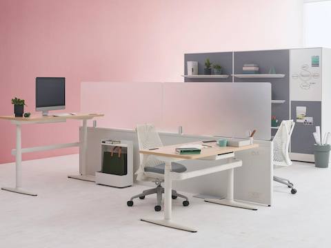 Two Catena Office Landscape workstations with white legs, a light wood surface, and glass add-on screens accompanied by Sayl Chairs. Port Storage System is featured in the background.
