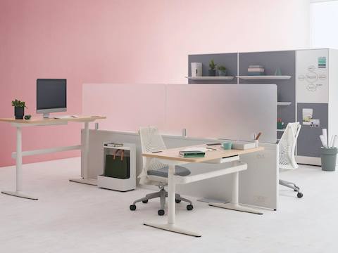 Two Catena Office Landscape workstations with white legs, a light wood surface, and glass add-on screens accompanied by Sayl Chairs. Port Storage System is featured in the background. Two Catena Office Landscape workstations with white legs, a light wood surface, and glass add-on screens accompanied by Sayl Chairs. Port Storage System is featured in the background.