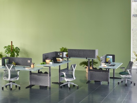 A zigzag configuration of four height-adjustable Atlas Office Landscape desks with blue tops and Sayl office chairs. A zigzag configuration of four height-adjustable Atlas Office Landscape desks with blue tops and Sayl office chairs.