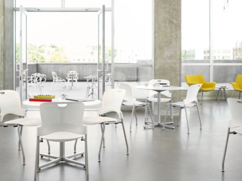 A student gathering space with floor-to-ceiling windows, white Caper Stacking Chairs, and yellow Swoop Lounge Chairs. A student gathering space with floor-to-ceiling windows, white Caper Stacking Chairs, and yellow Swoop Lounge Chairs.