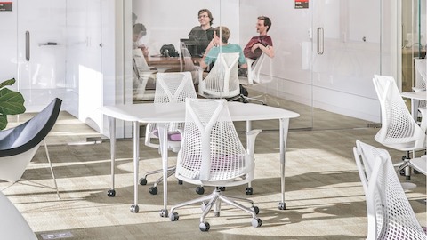 College students participate in a study group while sitting in white Sayl Chairs. 