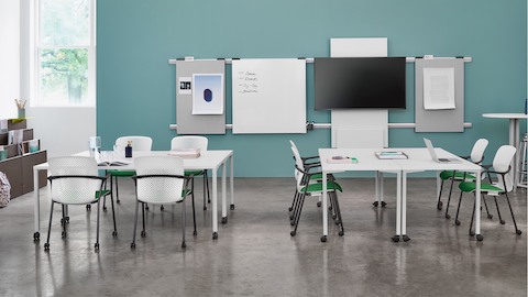 A classroom featuring white Everywhere Tables, white Keyn side chairs with green seat pads, and Metaform Portfolio blocks.