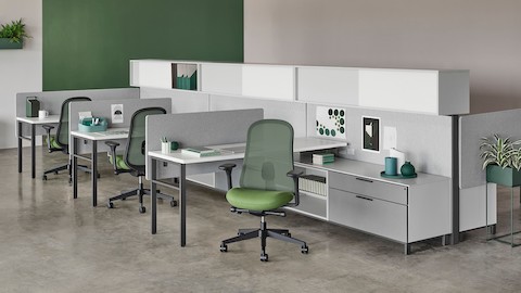 Canvas Wall workstation with gray screens, upper storage, and green Lino chairs.