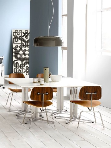 Four Eames Molded Plywood Chairs surround white Everywhere Tables in a break area. 