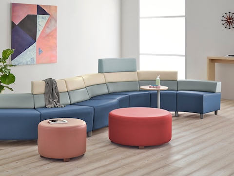 A curved configuration of the Steps Lounge System, featuring modules of blue, light gray and beige with varying back heights.