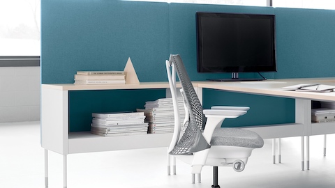 A Public Office Landscape workstation with a blue privacy screen and light gray Sayl office chair.