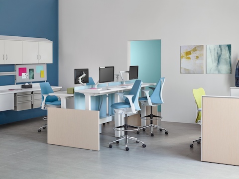 Co/Struc modular storage components, light blue Sayl stools, and green Mirra 2 office chairs in a caregiver work environment. 