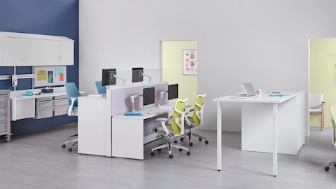 Co/Struc modular storage components, light blue Sayl stools, and green Mirra 2 office chairs in a caregiver work environment. 