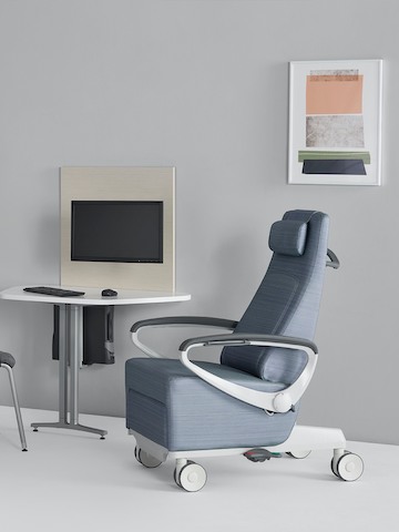 A light blue Ava patient chair with a Mora System peninsula on the side wall in an exam room setting. A light blue Ava patient chair with a Mora System peninsula on the side wall in an exam room setting.