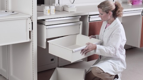 A nurse reconfigures drawers in a Co/Struc System modular storage unit.
