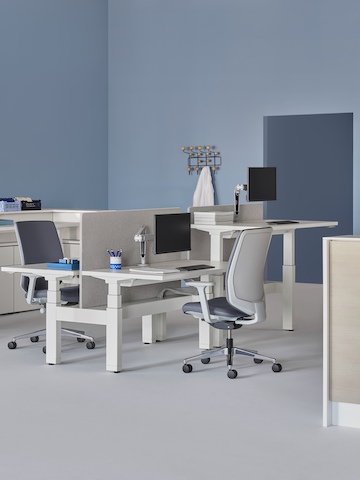 A caregiver team environment with a white and wood laminate prefab Commend Nurses Station, Verus Chairs, Renew Link, and Renew Sit-to-Stand Tables.