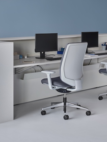 An interior view of a prefab Commend Nurses Station with a white work surface, white Corian transaction surfaces, Verus Chairs, and monitor stands. An interior view of a prefab Commend Nurses Station with a white work surface, white Corian transaction surfaces, Verus Chairs, and monitor stands.