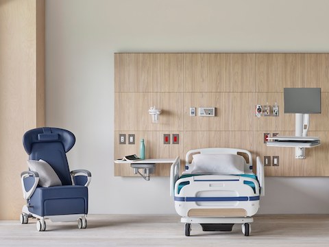 A Compass System headwall in a patient room with a blue Ava Recliner and MBrace technology support.