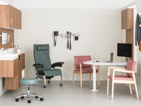 An exam room containing a patient recliner, caregiver stool, two side chairs, and wall-hung storage from the Compass System. An exam room containing a patient recliner, caregiver stool, two side chairs, and wall-hung storage from the Compass System.