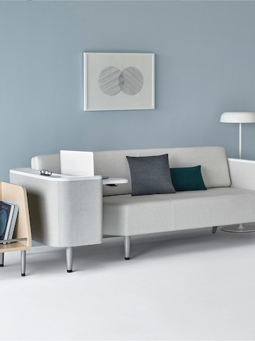 A patient room with a Palisade Flop Sofa in light gray upholstery with a Palisade Tote on one side and an Ode floor lamp on the other side. A patient room with a Palisade Flop Sofa in light gray upholstery with a Palisade Tote on one side and an Ode floor lamp on the other side.