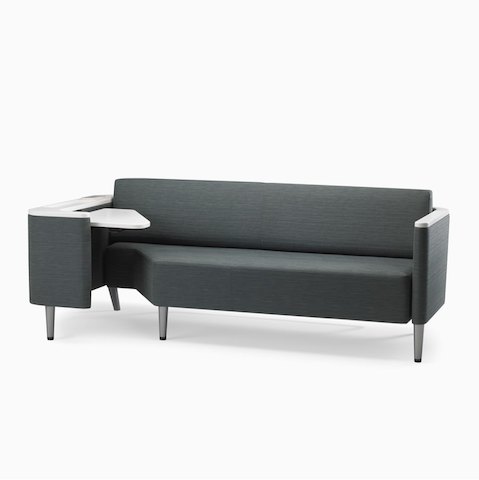 A Palisade Flop sofa in dark gray textile with white solid surface arms caps and white adjustable table with Durawrap top.