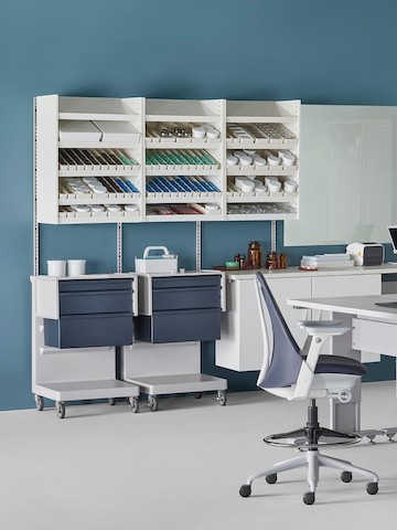 A pharmacy environment with a Co/Struc System dispensing system, L Carts, and a Sayl Stool.