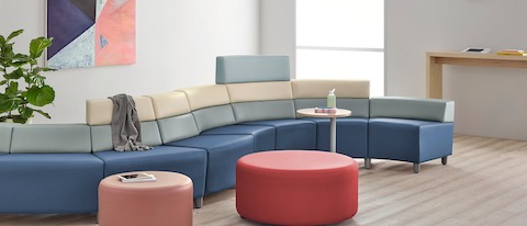 A curved configuration of the Steps Lounge System, featuring modules of blue, light gray and beige with varying back heights. A curved configuration of the Steps Lounge System, featuring modules of blue, light gray and beige with varying back heights.