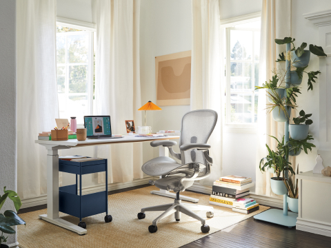 Light gray Aeron Chair with a Renew Sit-to-Stand Table in a home office setting.