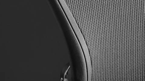 Close-up of the mesh back on a black Aeron office chair.