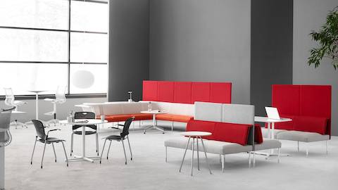 一个社交和协作空间，包括Caper堆叠椅，Setu凳子和Public Office Landscape座椅，橙色，红色和白色。