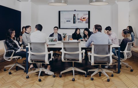 Several young co-workers at Harry's, the men's grooming company, sit around a conference table in gray Setu office chairs. Several young co-workers at Harry's, the men's grooming company, sit around a conference table in gray Setu office chairs.