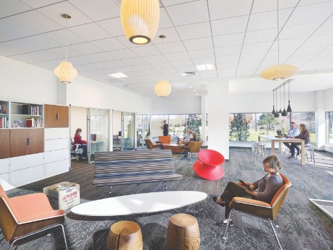 Este espacioso Plaza Setting tiene un sofá Eames, una silla Magis Spun roja, un par de sillas Swoop en tapicería de color naranja quemado, y una mesa Eliptical Base Eames Wire.