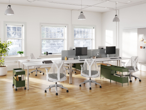 Four grey OE1 Rectangular Tables joined together to form a bench, with a grey OE1 Project Table, green OE1 Storage Trolleys and white Sayl Chairs in the foreground and an OE1 Wall Rail and Board in the background.