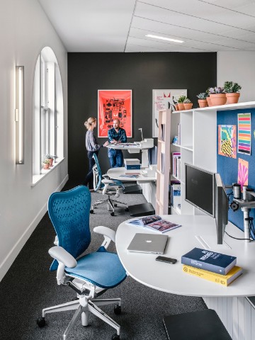 A Hive Setting furnished with blue Mirra 2 Chairs and Locale sit-to-stand desks. 