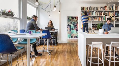 People working in an open office kitchen space.