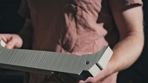 A person holds onto an unfired clay molded piece.