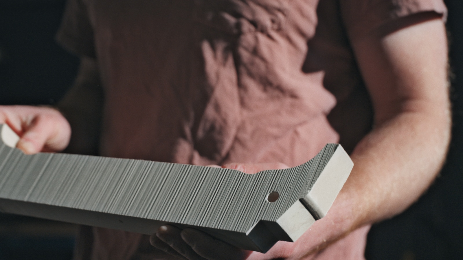 A person holds onto an unfired clay molded piece.