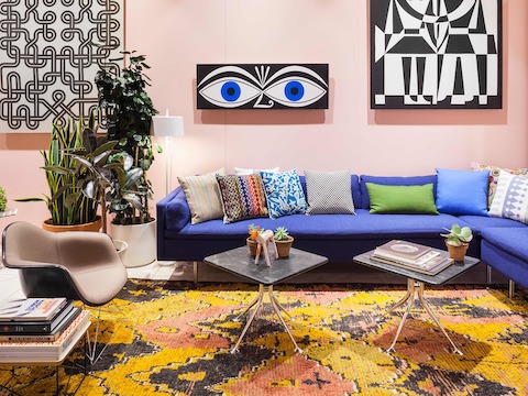 A new Bolster sofa by BassamFellows upholstered in Girard's Superweave textile from Maharam and an Eames Upholstered Molded Fiberglass Arm Chair on a A new Bolster sofa by BassamFellows upholstered in Girard's Superweave textile from Maharam and an Eames Upholstered Molded Fiberglass Arm Chair on a