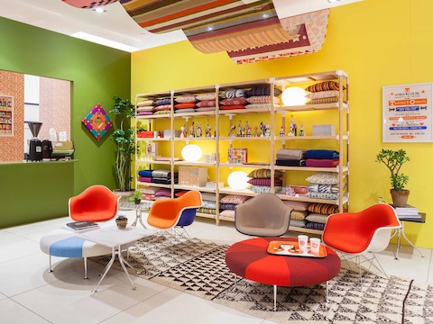 Girard's Color Wheel Ottomans and Eames Upholstered Molded Fiberglass Arm Chairs form the basis of a Girard-inspired living room.