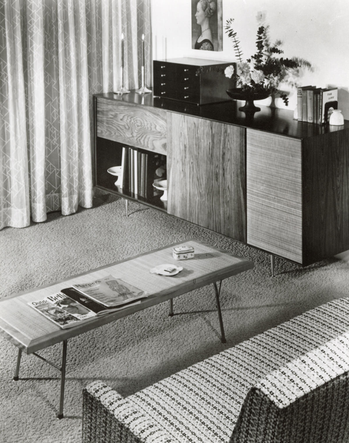 A speaker cabinet from the Nelson Basic Cabinet Series sits in a living room featuring a Nelson Cane Bench being utilised as a coffee table in the centre positioned in front of a partially visible sofa.