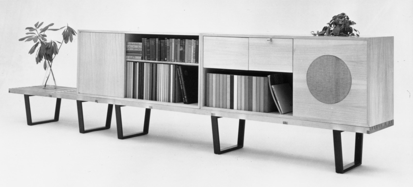 Two side-by-side Nelson platform benches supporting two bookcases, one featuring a radio phono speaker cabinet.