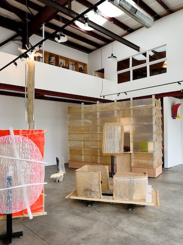 Phantom-22, an exhibition by Minjae Kim featuring quilted fiberglass sculptures and screens, is on display in the gallery space with cement floors and white walls.