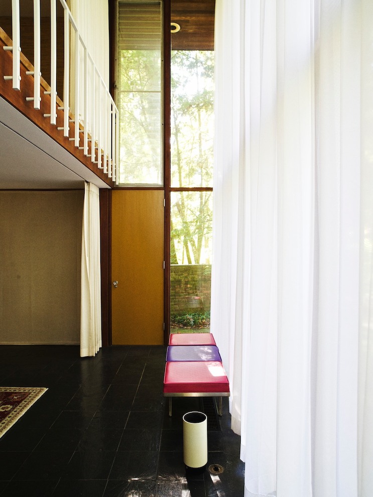 Conceived as a 2-story apartment that could be closed off from the rest of the house, the suspended master bedroom opens onto a bank of floor-to-ceiling windows in the living room.