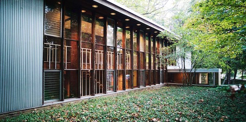 El exterior de una casa moderna con una pared de ventanas.