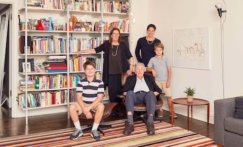 Five family members pose near a bookcase.