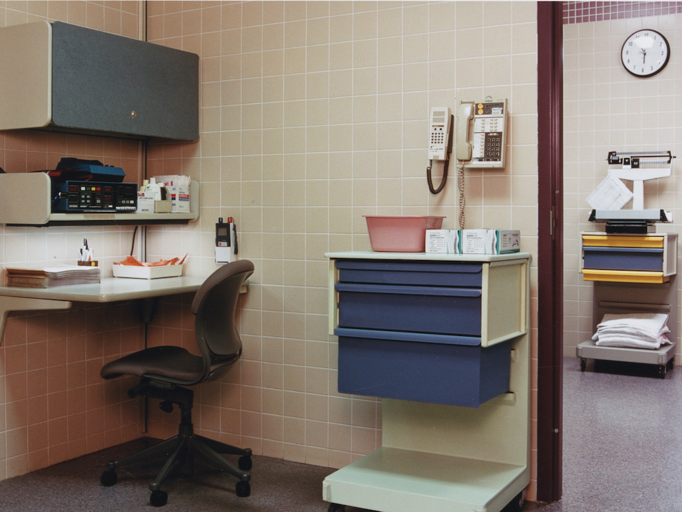 Co/Struc L cart with a C-frame and blue drawers next to Action Office workstation with overhead storage, with Equa chair.