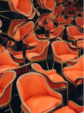 A Landmark Chair and its many reflections fill a tiny mirrored room. A Landmark Chair and its many reflections fill a tiny mirrored room.