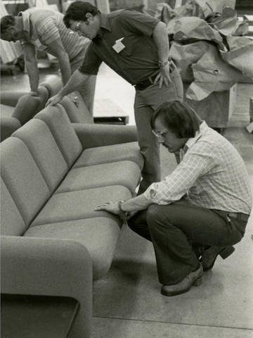 Black and white photo of product development team inspecting Wilkes Modular Sofas during manufacturing process.