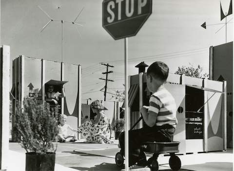 Uma foto vintage de crianças brincando entre caixas grandes.