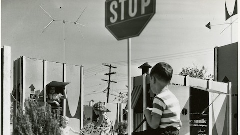 Una foto de época de niños jugando entre cartones grandes. Seleccione para ir a un artículo sobre Ray y Charles Eames y su enfoque lúdico para el diseño.
