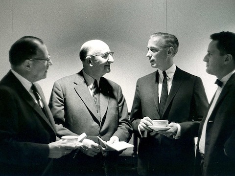 A black-and-white photo of Herman Miller founder D.J. De Pree with three colleagues. A black-and-white photo of Herman Miller founder D.J. De Pree with three colleagues.