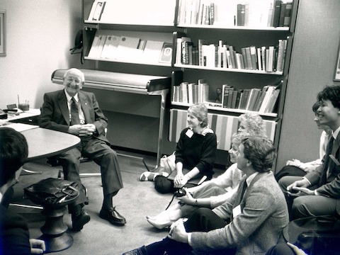 A black-and-white photo of Herman Miller founder D.J. De Pree chatting informally with a group of young people. A black-and-white photo of Herman Miller founder D.J. De Pree chatting informally with a group of young people.