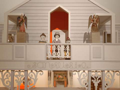 Handcrafted folk art depicting figurines on the balcony of a building. Handcrafted folk art depicting figurines on the balcony of a building.